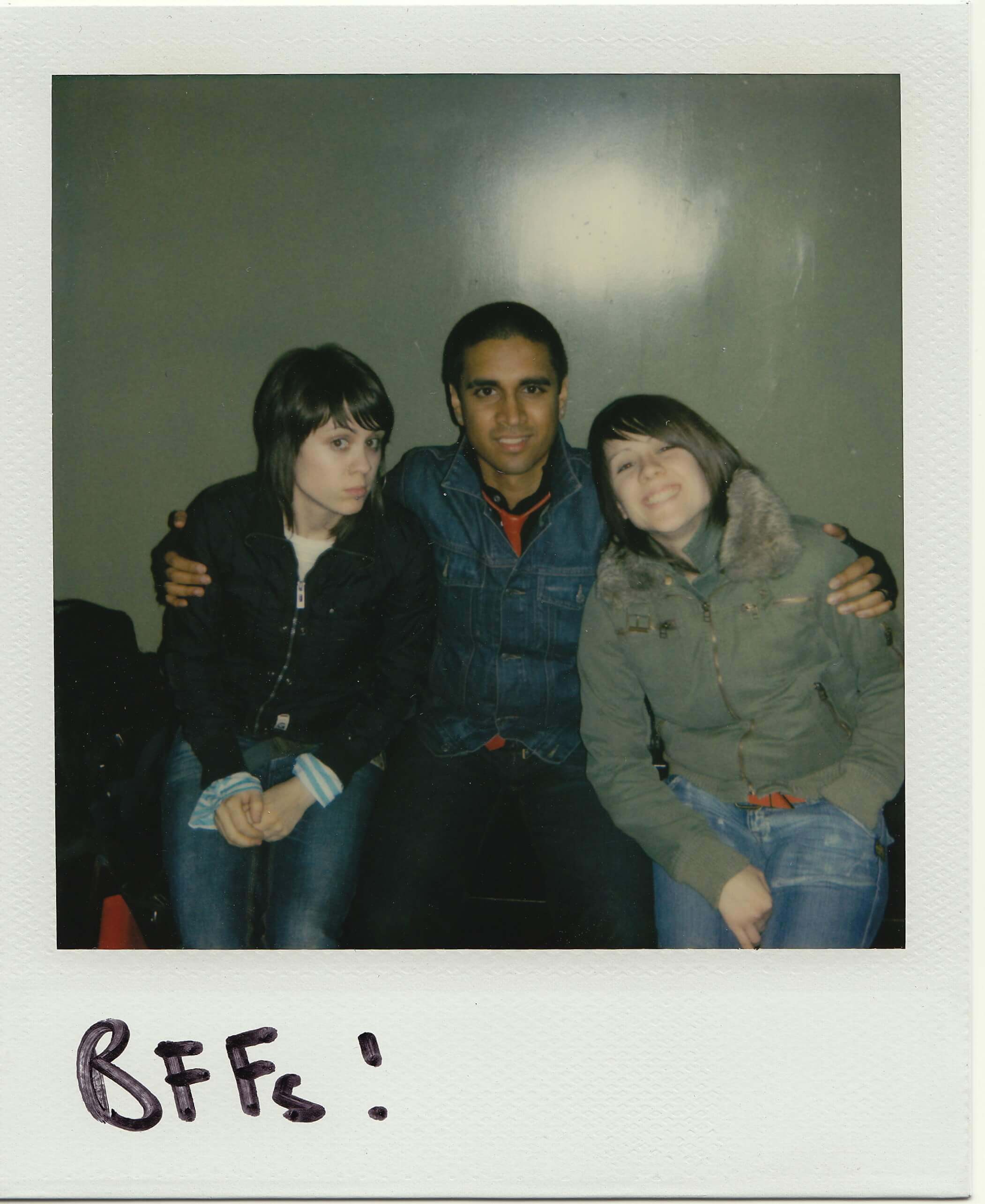 A Polaroid photo of Vivek with her arms around Tegan and Sara, with a handwritten caption: “BFFs!”